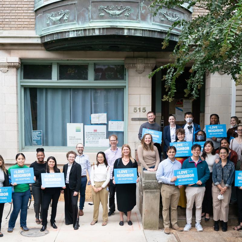 FCNL Advocacy Corps organizers stand outside Friends Place holding "Love Thy Neighbor" signs